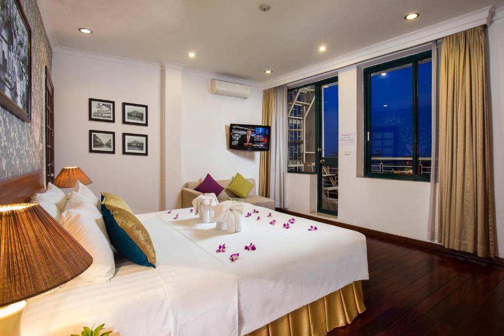 a bedroom with a large white bed with flowers on it at Hanoi 3B Premier Hotel in Hanoi