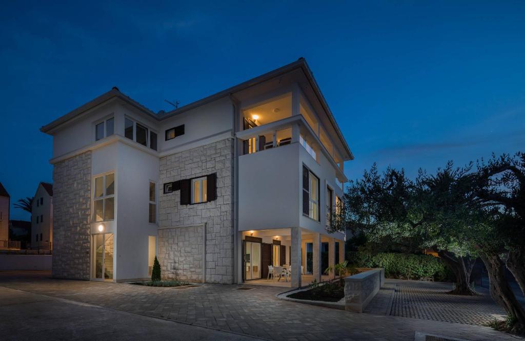 a large white house at night at Apartmani Kos in Supetar