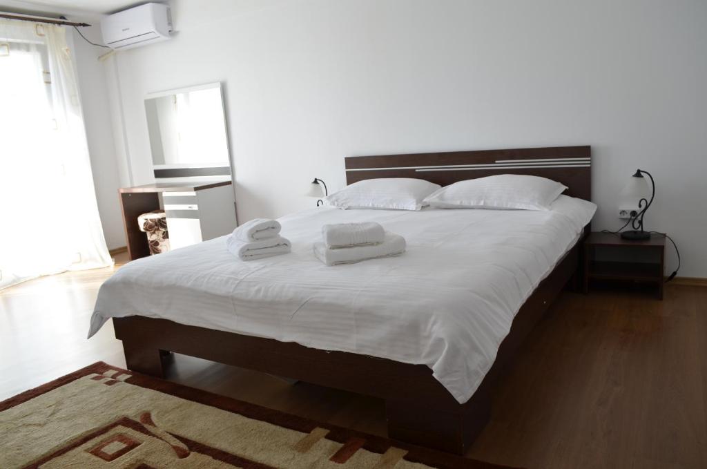 a bedroom with a large bed with two towels on it at Alexys Residence 9 in Iaşi