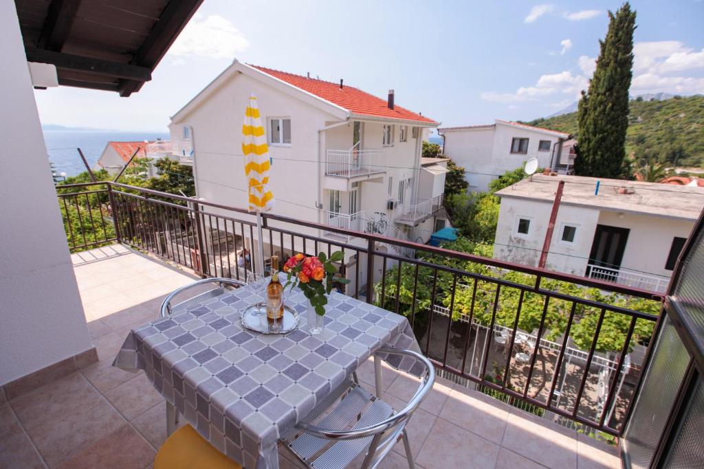 un balcone con tavolo e fiori di Apartments Adna a Podaca