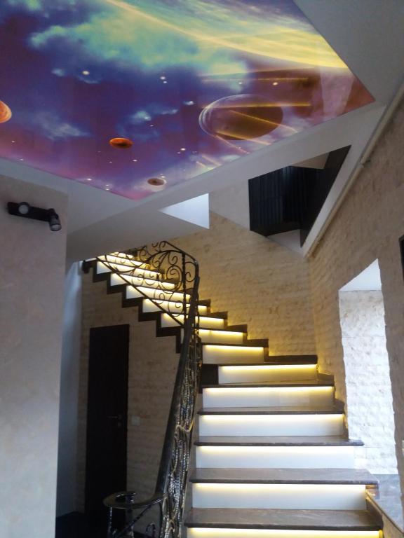 a staircase with a painting on the ceiling at Casa Lipianu in Târgu Jiu