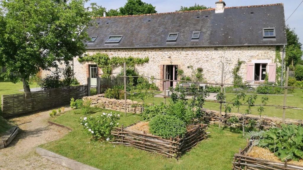 ein altes Steinhaus mit Garten davor in der Unterkunft La maison d'Alcime in Plumergat