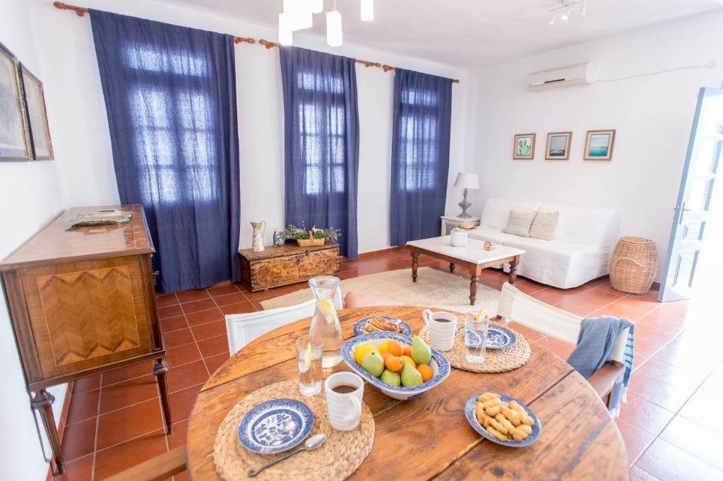 una sala de estar con una mesa con fruta. en Eirinaki House en Patmos