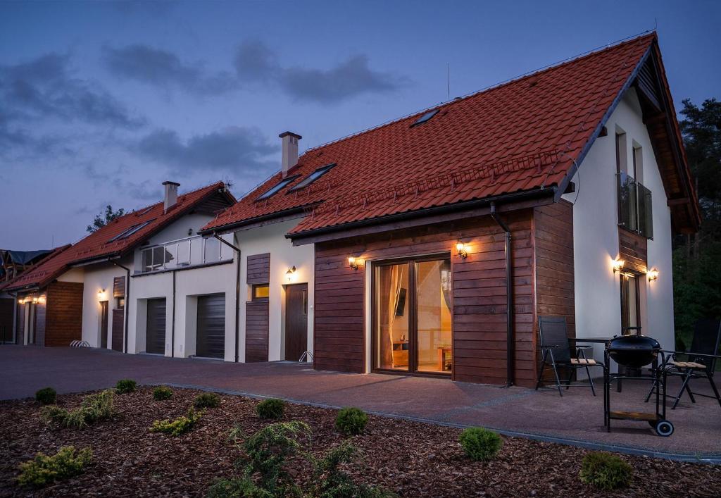 a house with a roof with a table and chairs at Apartamenty bez barier in Rydzewo