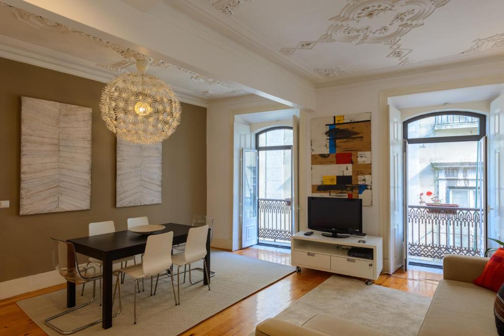 sala de estar con mesa de comedor y lámpara de araña. en Beautiful apartment in Bairro Alto - Quite en Lisboa