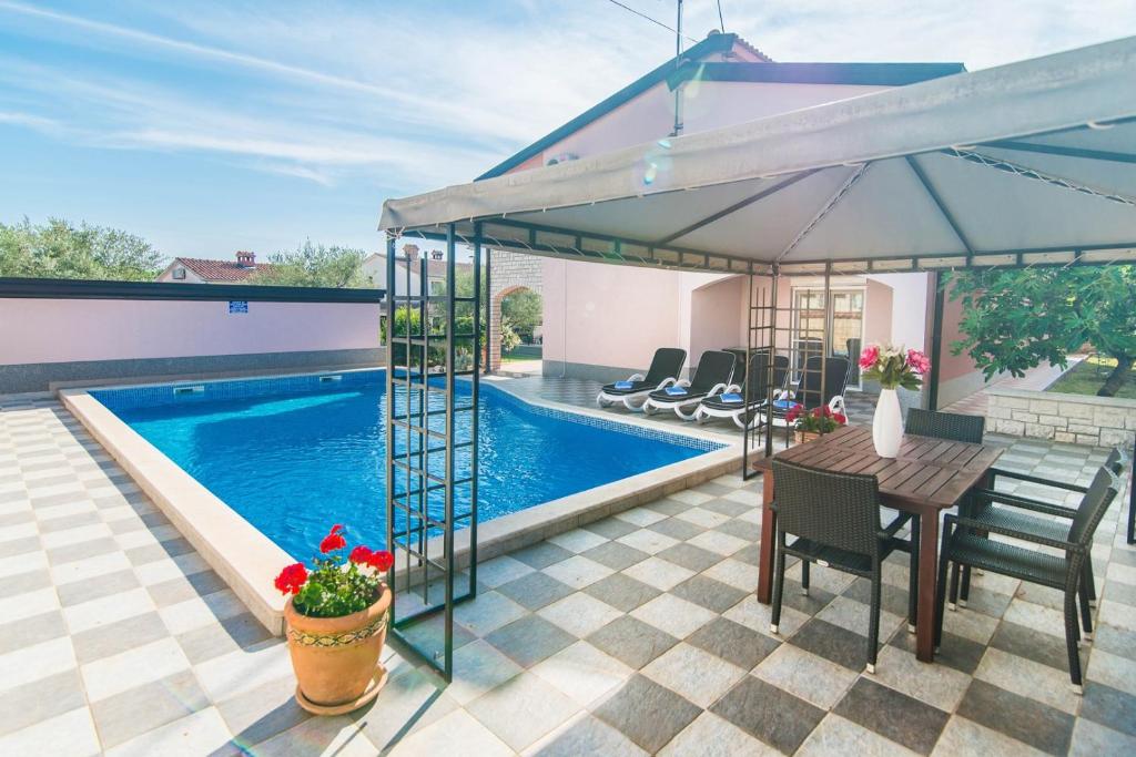 a patio with a table and a swimming pool at Apartment Salha in Nova Vas
