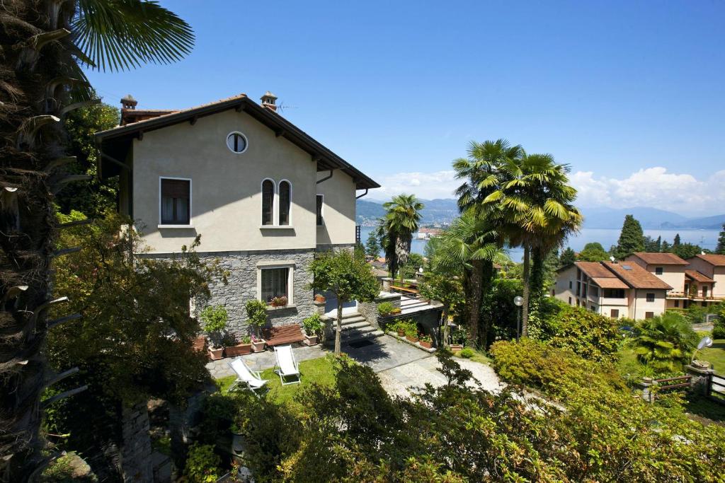 ein Haus auf einem Hügel mit Palmen in der Unterkunft Casa Vista Isole Borromee in Stresa