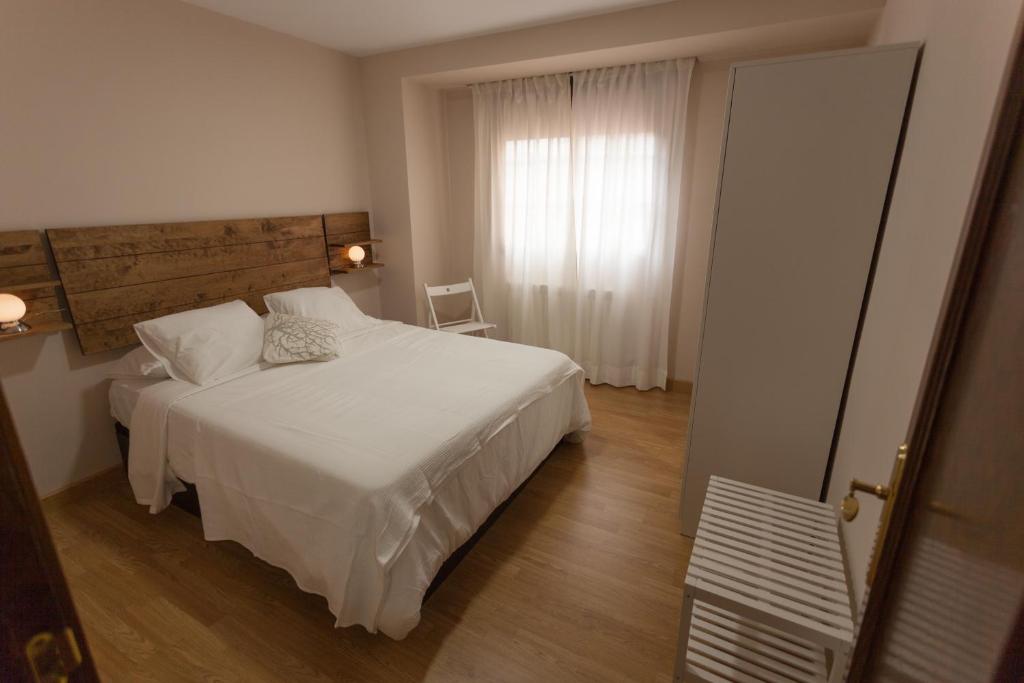 una camera con un letto bianco e una finestra di Apartamento Monachil Pueblo a Monachil
