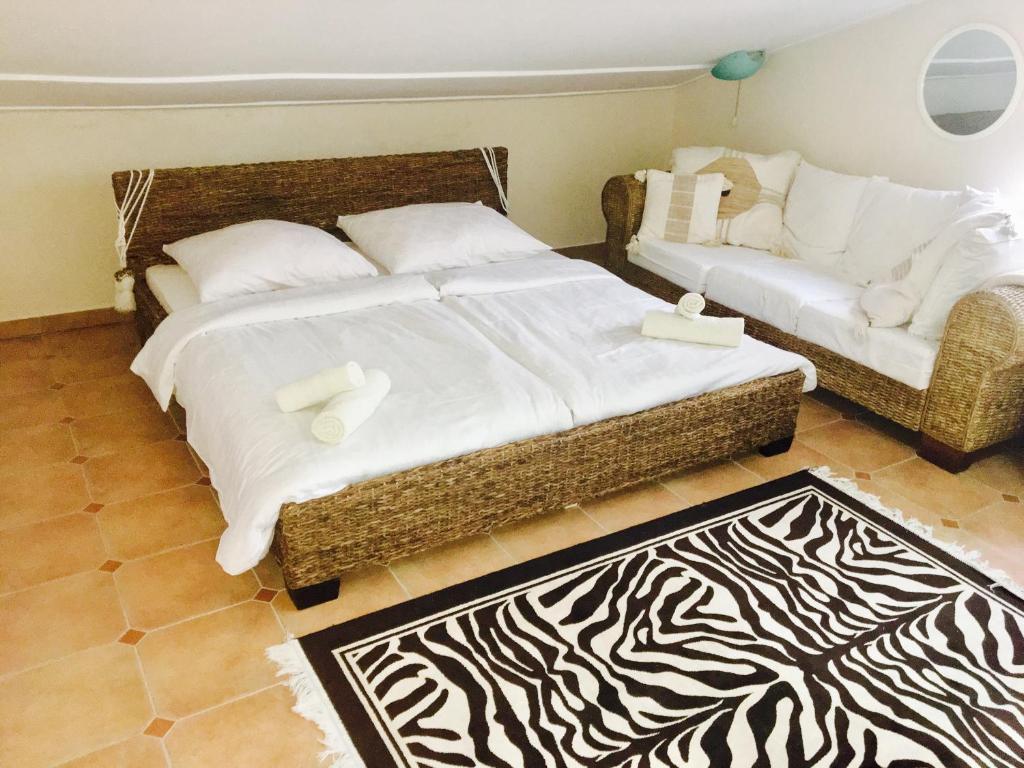 a bedroom with a large bed and a couch at Vila Ceder in Krk