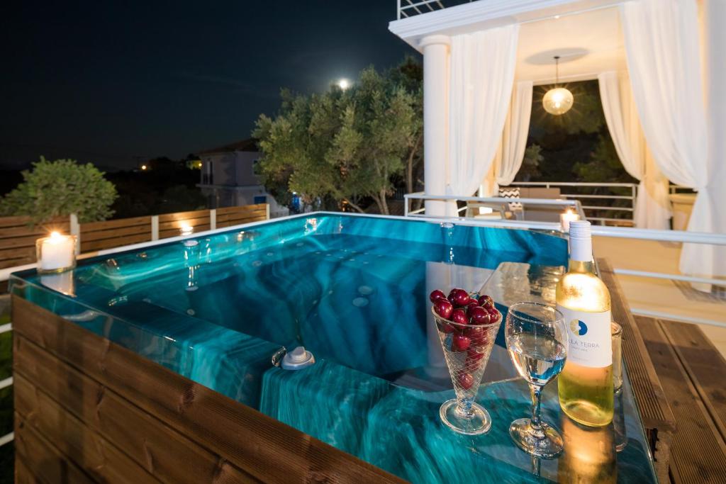 Lithakia的住宿－Villa Annaset，热水浴池,配有一瓶葡萄酒和酒杯