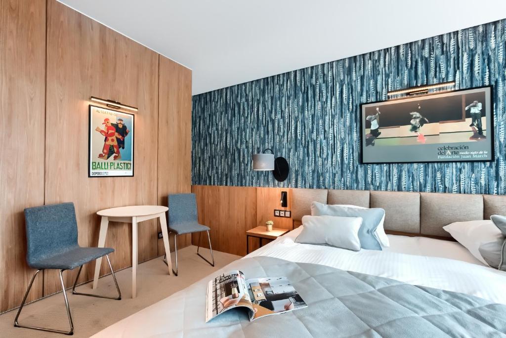 pokój hotelowy z łóżkiem i 2 krzesłami w obiekcie City Apartments - Marii Ludwiki 7 w Koszalinie