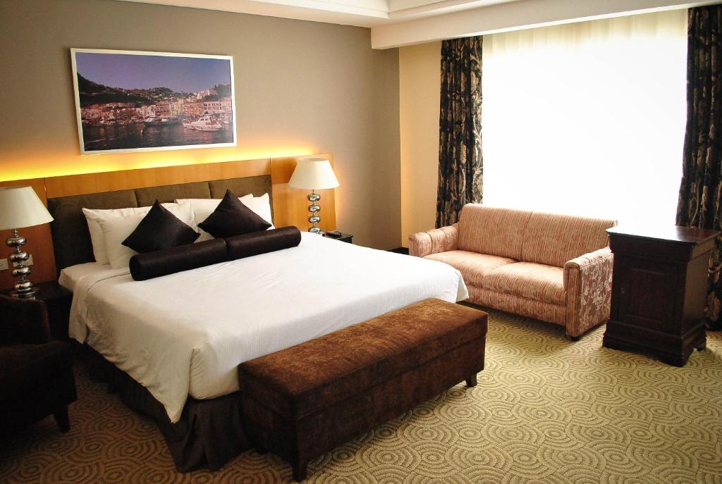 Pokój hotelowy z dużym łóżkiem i krzesłem w obiekcie Hotel Elizabeth Cebu w Cebu
