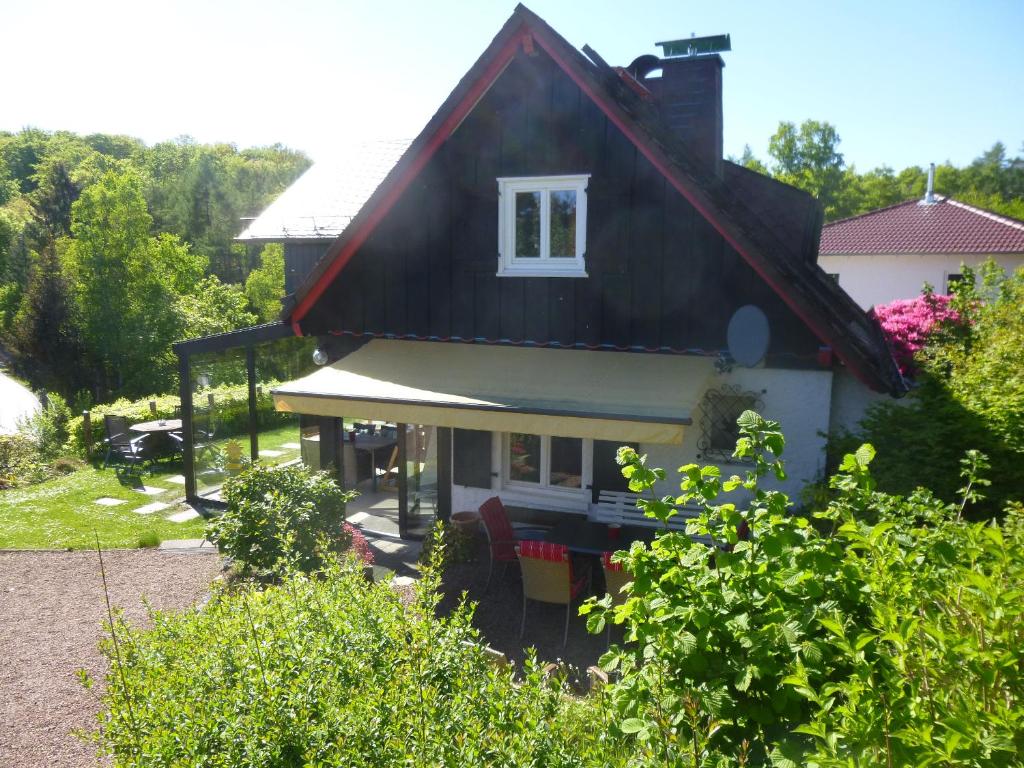 une petite maison avec un toit noir dans l'établissement Panoramaferienhaus Sorpesee, à Sundern