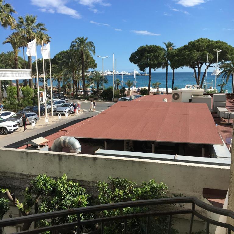 - une vue sur un bâtiment avec un toit rouge dans l'établissement Appartement Le Palais Des Iles, à Cannes