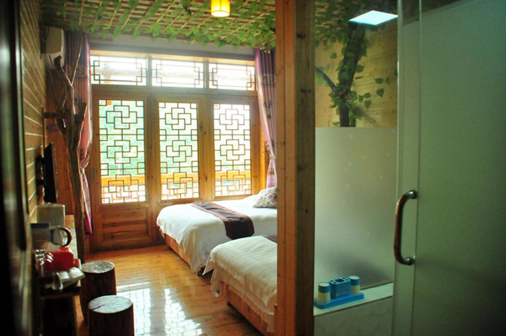 a room with a bedroom with a bed and a window at Yangjiajie Inn in Zhangjiajie