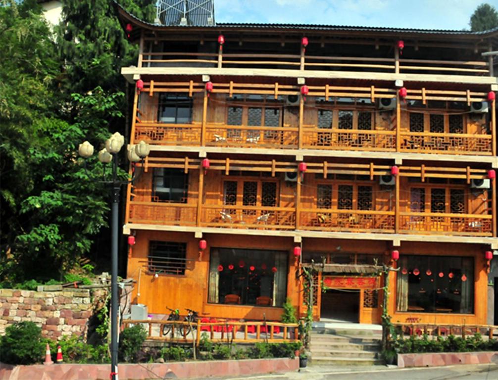 un grande edificio in legno con balcone di Yangjiajie Inn a Zhangjiajie