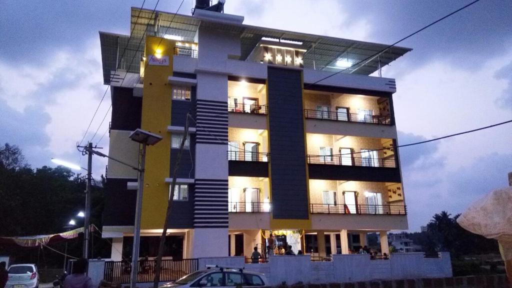 un edificio blanco y negro con gente en el balcón en Aikya en Mangalore