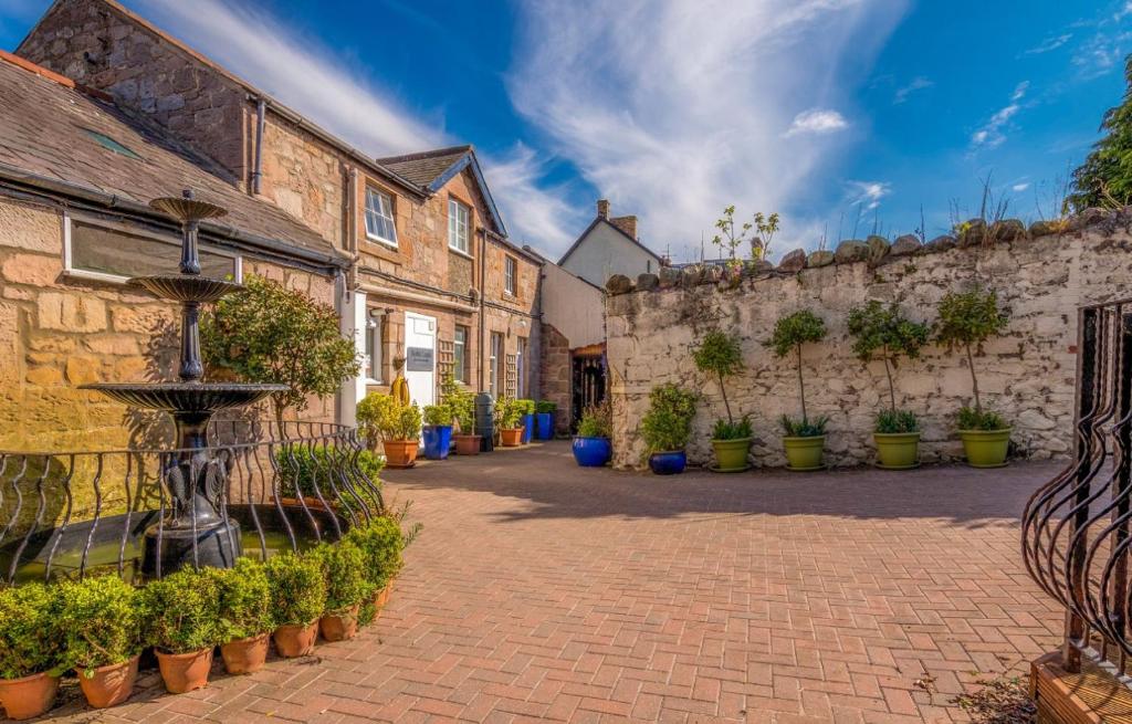 a courtyard of an old building with potted plants at Noble Lands in Wooler