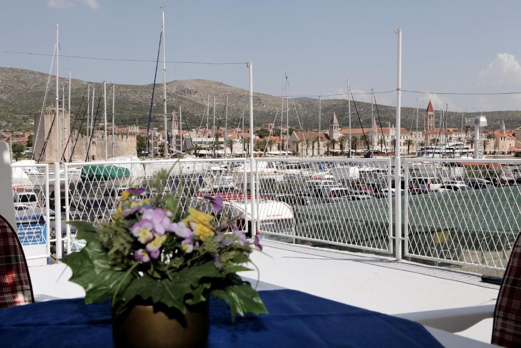 eine Vase voller Blumen auf einem Tisch mit einem Yachthafen in der Unterkunft Apartment Toncika in Trogir