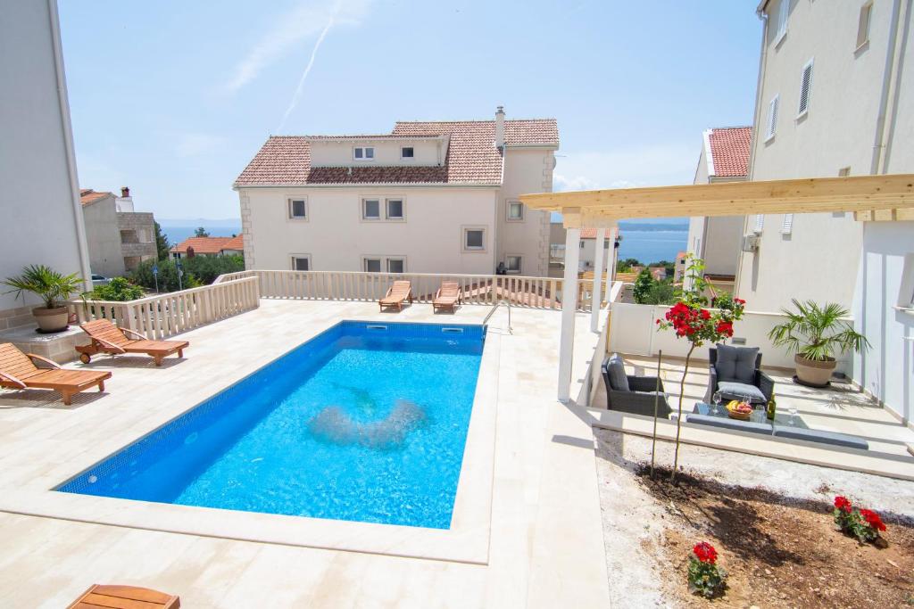 a swimming pool on a patio with a house at Apartments Sara 4 in Bol