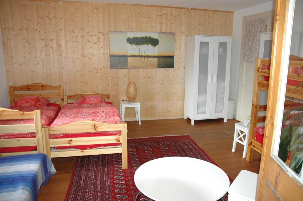 a bedroom with two beds and a table and a rug at Chalet la Griotte in Villars-sur-Ollon