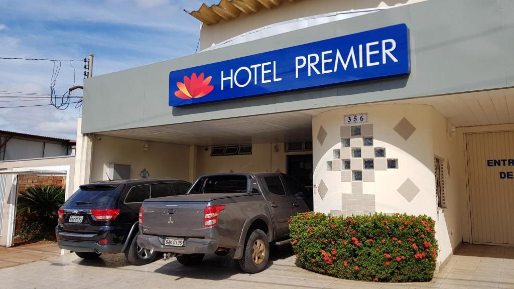 dos coches estacionados frente a un hotel premier en Hotel Premier, en Campo Grande
