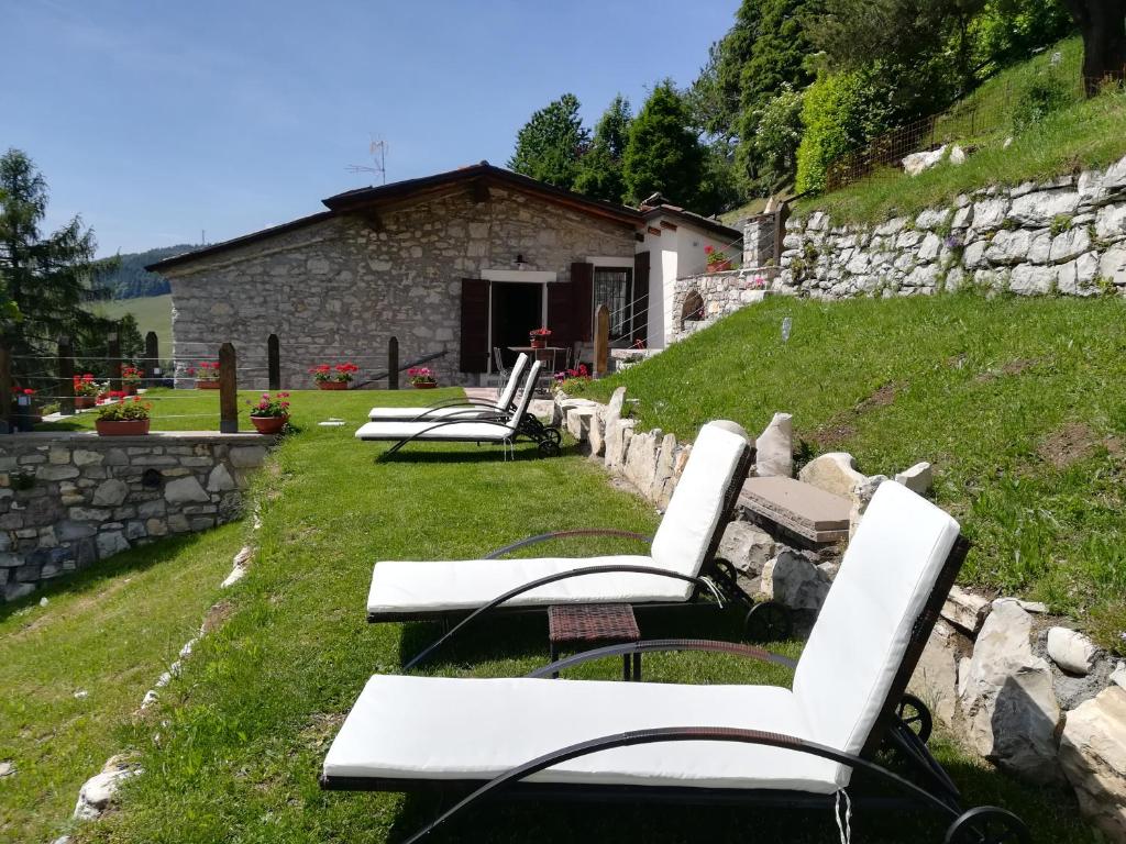 a group of white chairs sitting in the grass at Callort in Adrara San Rocco