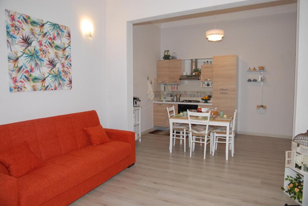 ein Wohnzimmer mit einem Sofa und einem Tisch mit Stühlen in der Unterkunft Il Cancelletto in Syrakus