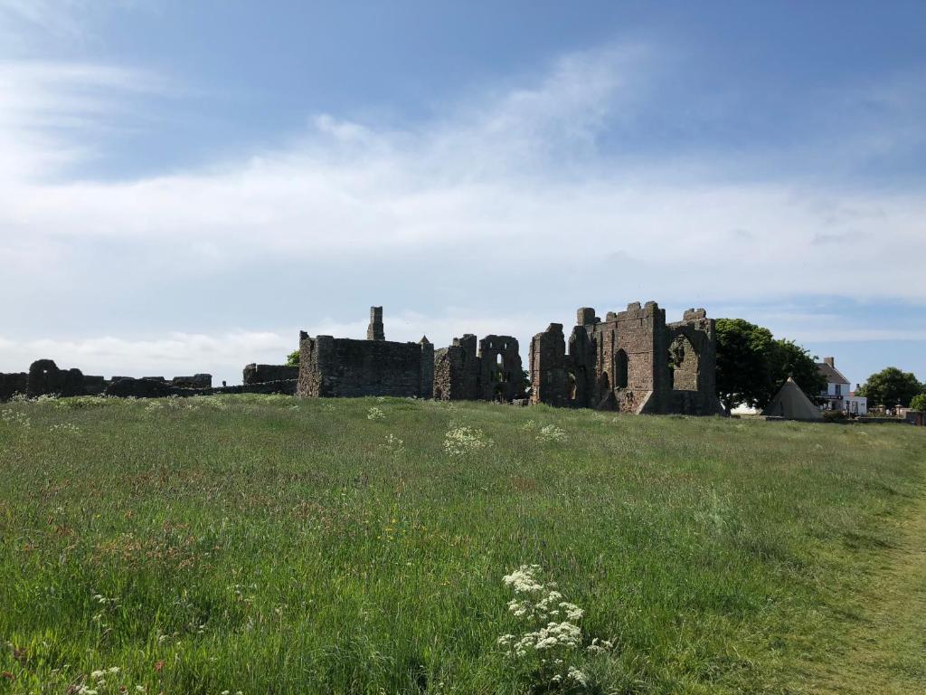an old castle on a hill with a field at The Old Vicarage in Berwick-Upon-Tweed