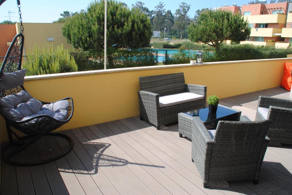 a patio with wicker chairs and a table on a balcony at Pine Beach Spot in Ovar