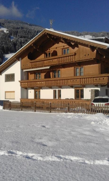 ein großes Holzgebäude auf einem schneebedeckten Dach in der Unterkunft Gästehaus Wildauer in Zell am Ziller