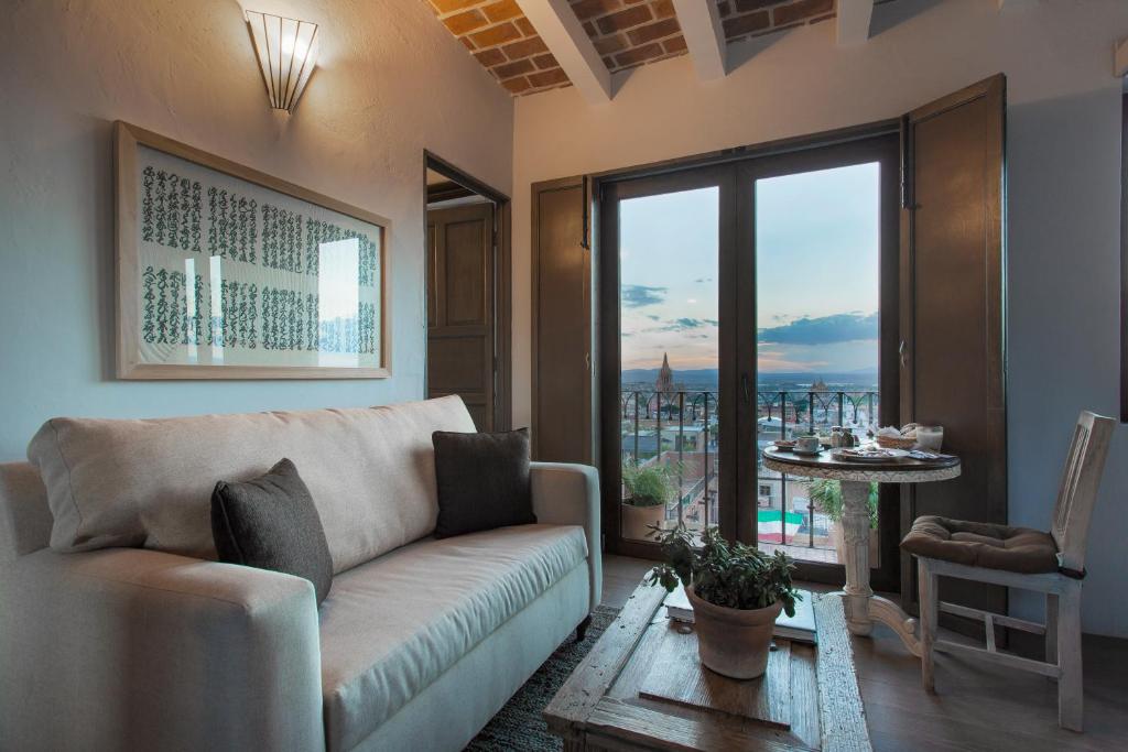 ein Wohnzimmer mit einem Sofa und einem großen Fenster in der Unterkunft Hotel Boutique El Palomar in San Miguel de Allende