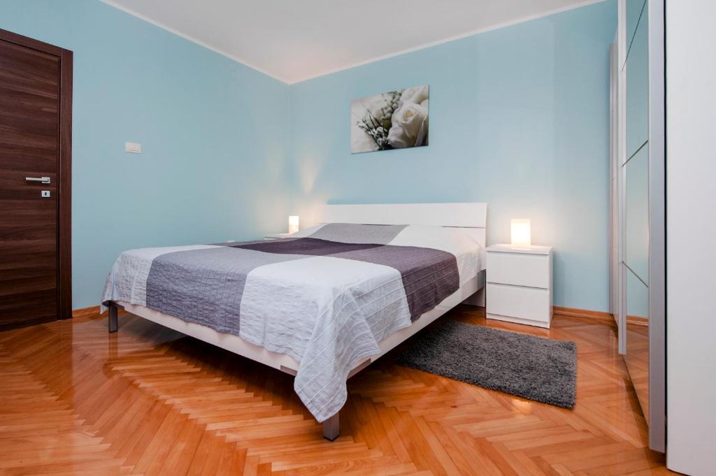 een slaapkamer met een groot bed en een houten vloer bij Apartment Anastasia in Rovinj