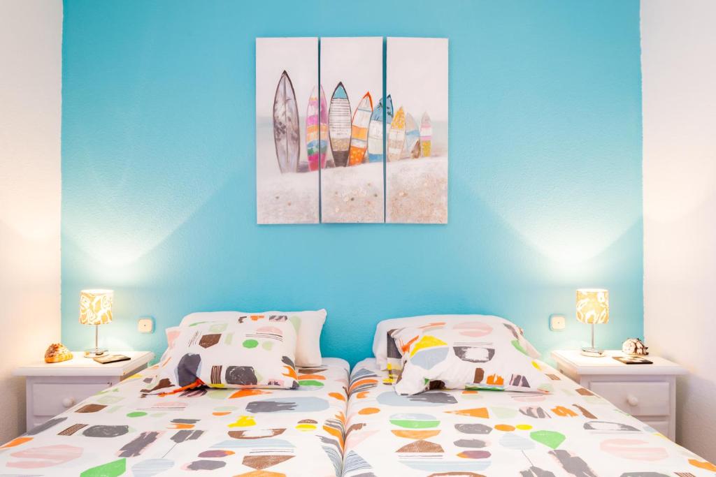 コラレホにあるMarina House Corralejo Centerのベッドルーム1室(ベッド1台付)、サーフボードの絵画