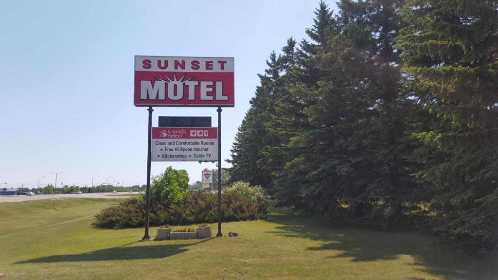 um sinal de motel ao pôr-do-sol na berma de uma estrada em Sunset motel em Portage La Prairie