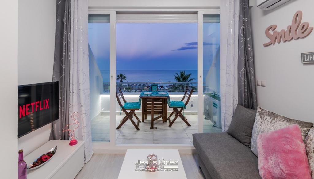 トレモリノスにあるRoca Chica A. Apartamento 211のリビングルーム(テーブル、椅子付)が備わり、海の景色を望めます。