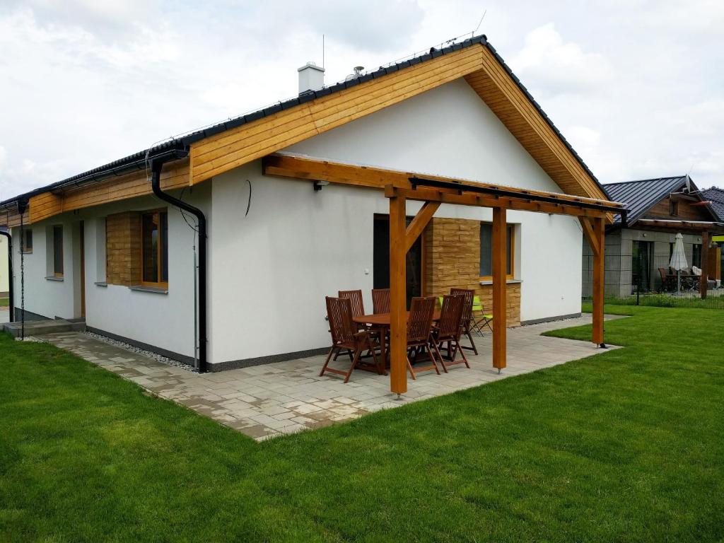 ein weißes Haus mit einem Holzdach in der Unterkunft Ski House Tatry in Liptovský Mikuláš