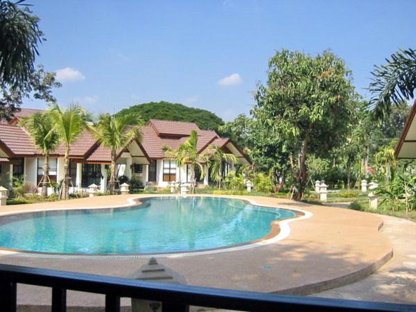 a swimming pool in front of a house at Pangrujee Resort in Nakhon Ratchasima