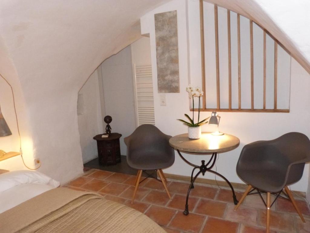 ein Schlafzimmer mit 2 Stühlen und einem Tisch in einem Zimmer in der Unterkunft le tilleul in Villevieille