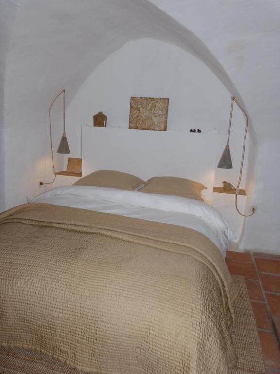 ein Schlafzimmer mit einem großen weißen Bett mit zwei Kissen in der Unterkunft le tilleul in Villevieille