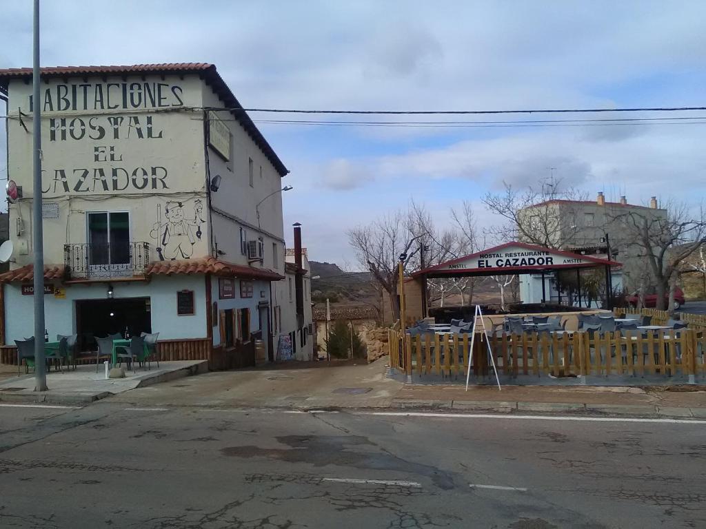 un antiguo edificio al lado de una calle en Hostal Restaurante el Cazador en Nuévalos