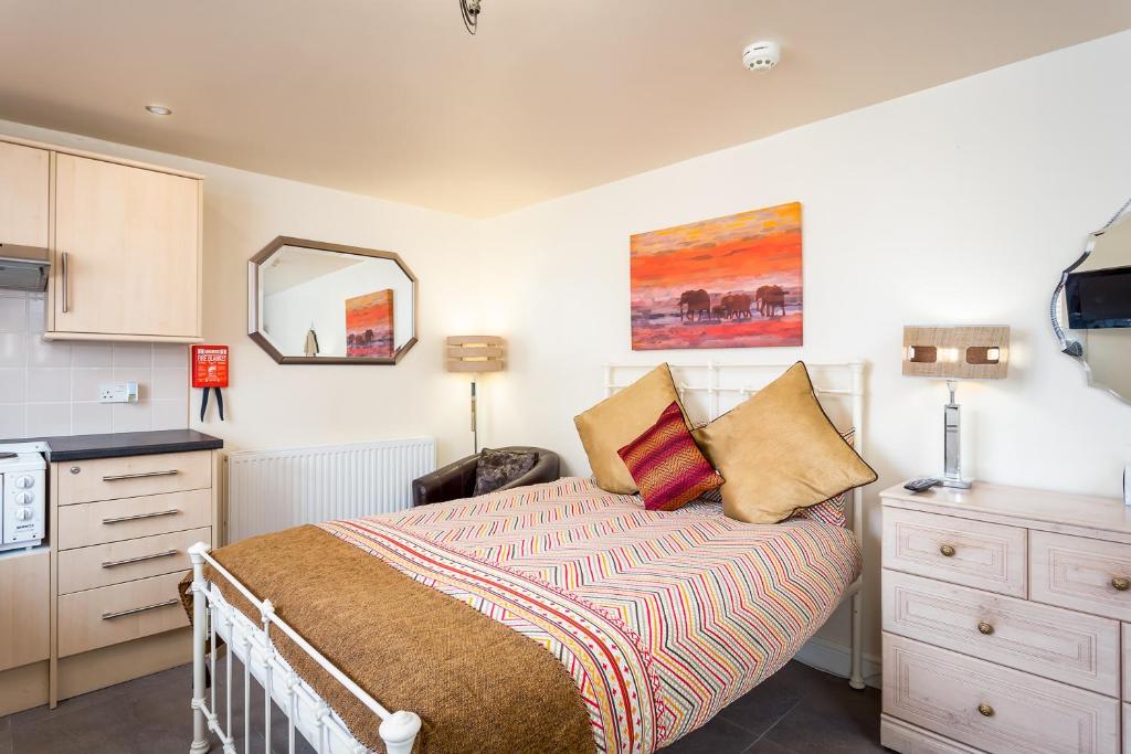 a bedroom with a bed and a dresser and a mirror at Stratford Studios in Stratford-upon-Avon