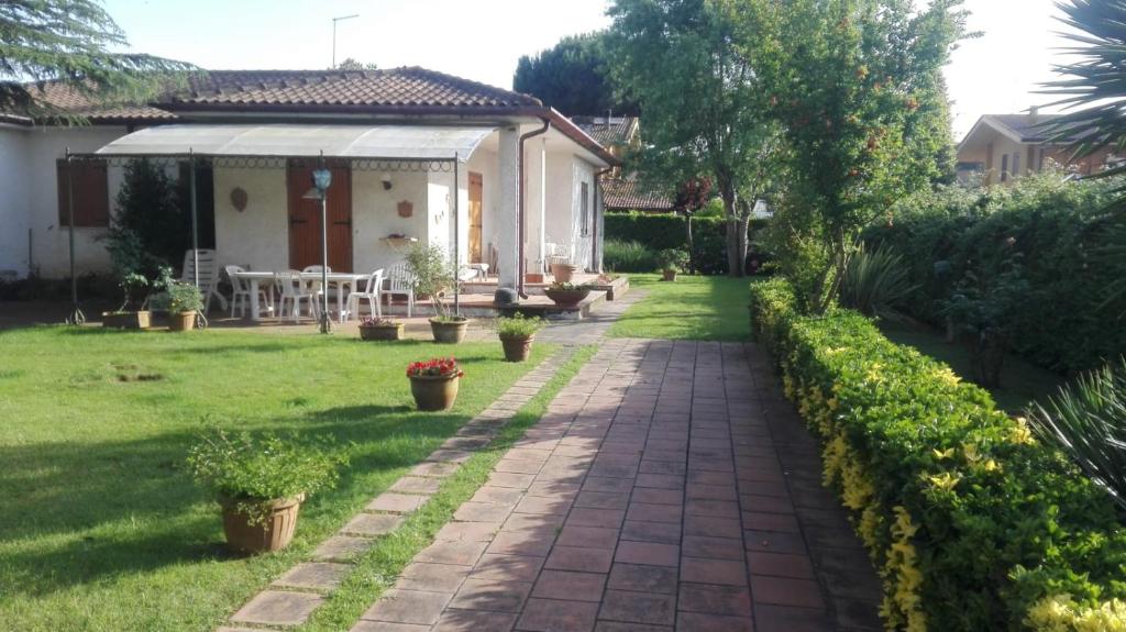 een tuin met een bakstenen pad naar een huis bij La casa di Angelo e Gladys in Bella Farnia