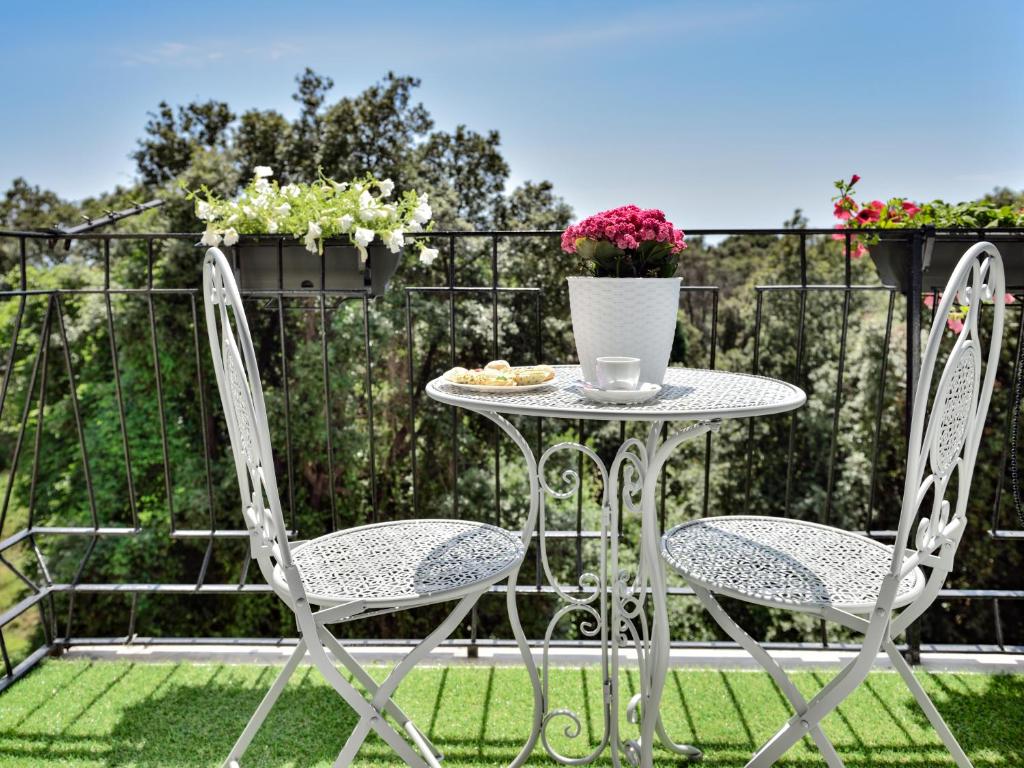 a table and chairs on a balcony with flowers at Insula House in Ercolano