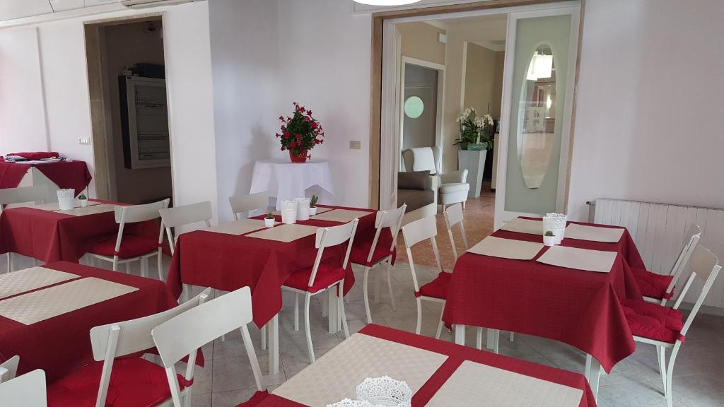 a restaurant with red and white tables and chairs at La locanda di Gioele in Lido di Camaiore