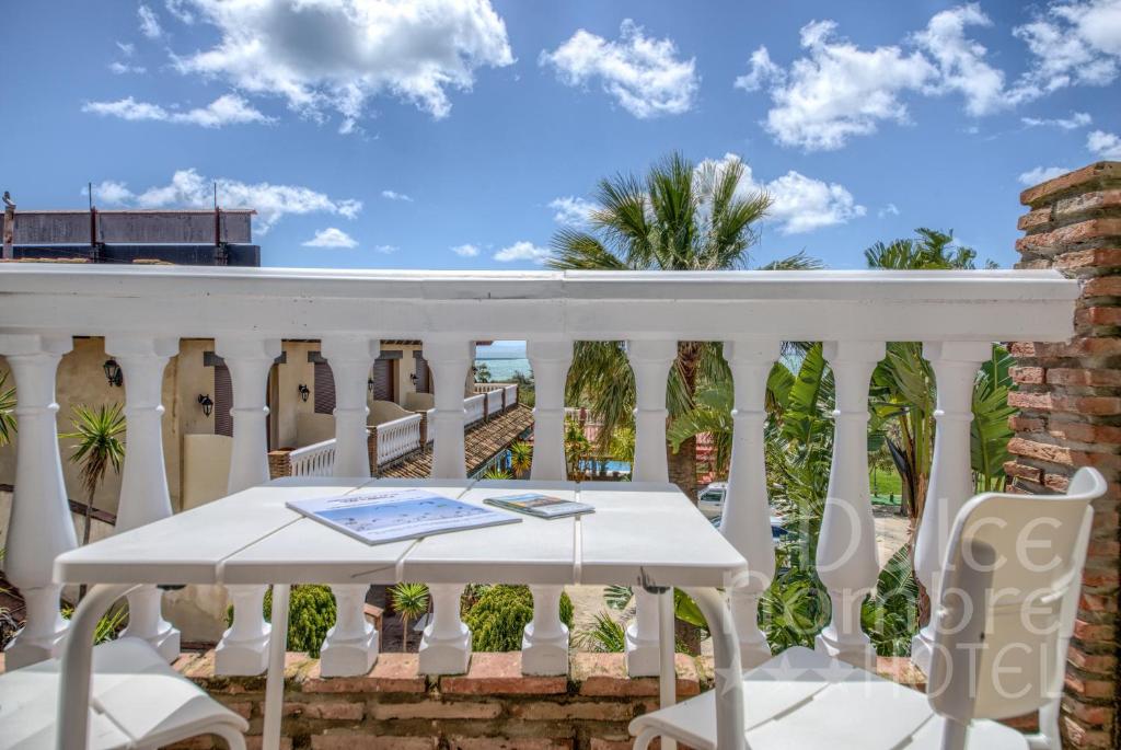 a white balcony with a table and chairs at Dulce Nombre Hotel - Apartamentos in Tarifa