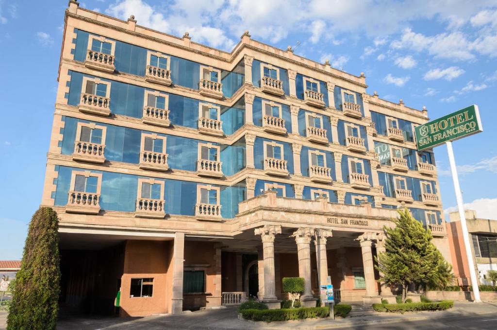 un edificio azul con un letrero de la calle delante de él en Hotel San Francisco Leon, en León