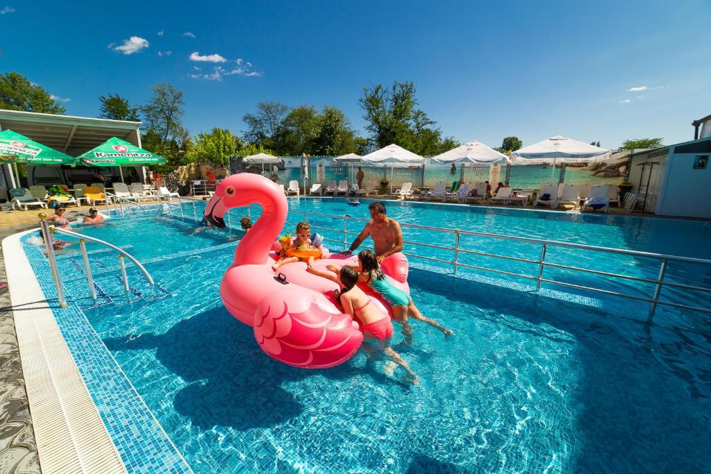 eine Gruppe von Menschen, die einen rosa Schwan im Pool reiten in der Unterkunft Hotel Royal Bath in Banya