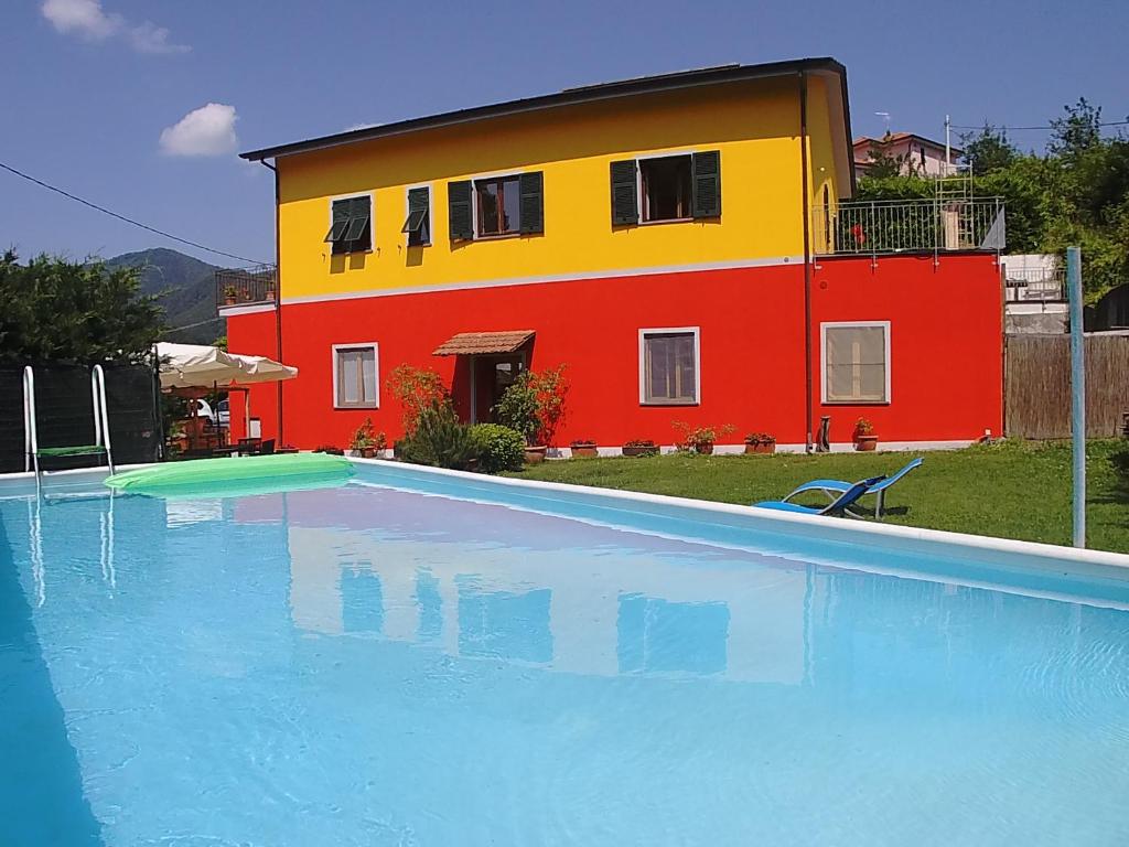 a house with a swimming pool in front of a building at Varavventura in Riccò del Golfo di Spezia