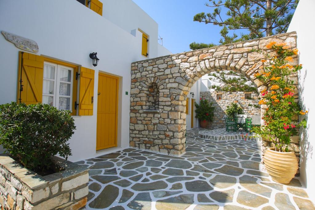 an entrance to a building with an arch and flowers at Ostria in Naousa